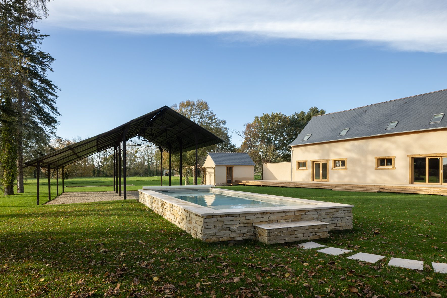 Le préau vide à côté de la piscine et de la maison